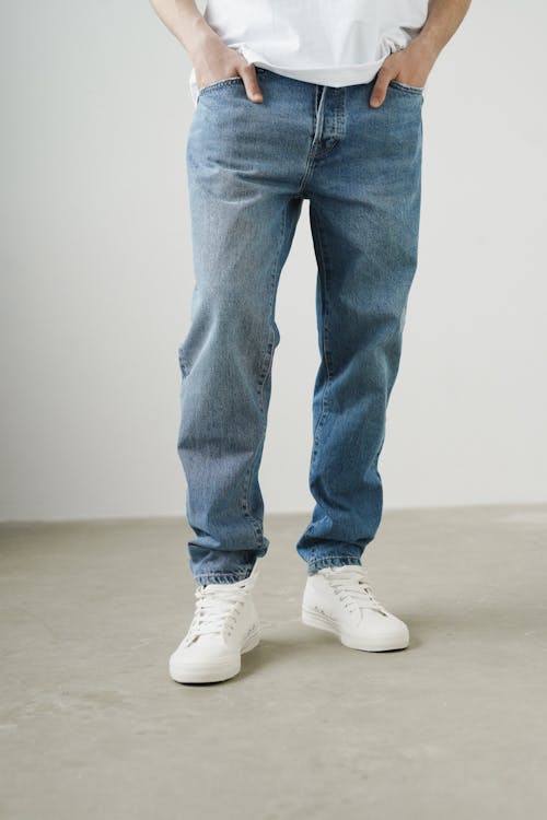 A Person Wearing Denim Pants and White Sneakers · Free Stock Photo