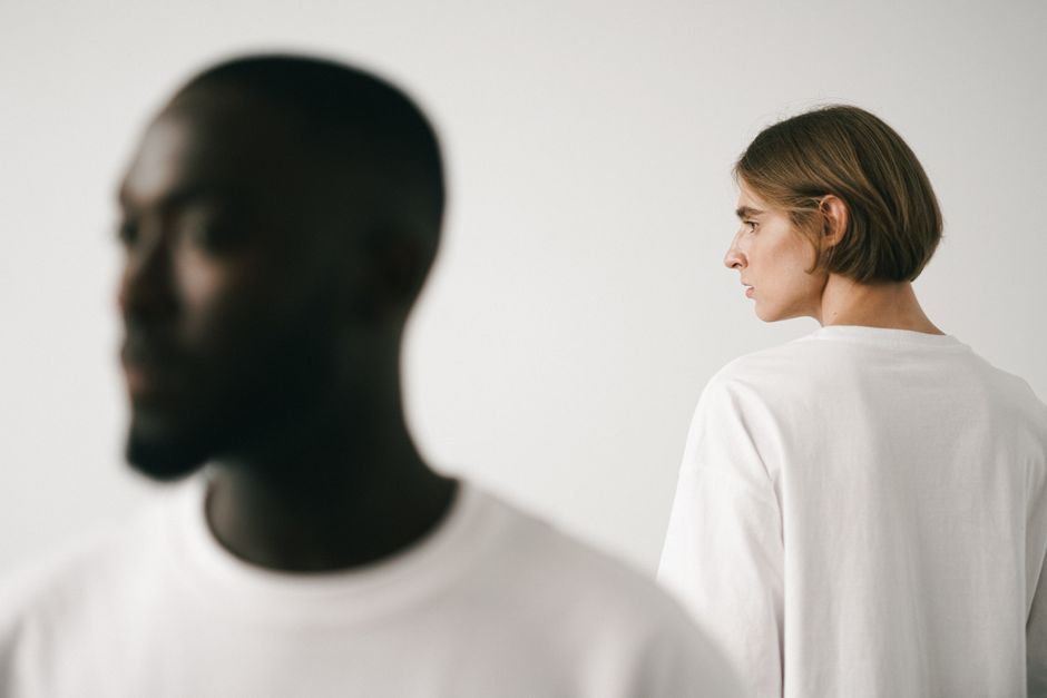 Como a Despersonalização Pode Afetar Seus Relacionamentos 2 Stylish studio portrait of two models, emphasizing minimalist fashion in white t-shirts.