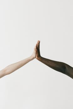 Two diverse hands giving a high five, symbolizing unity and diversity.