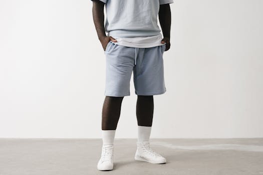 Stylish casual outfit featuring light blue shorts and white sneakers.