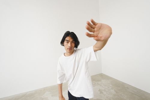 Free High angle portrait of a man in a white shirt reaching forward in a minimalist setting. Stock Photo