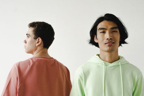 Free Minimalist portrait of two stylish men in casual outfits against a white background. Stock Photo