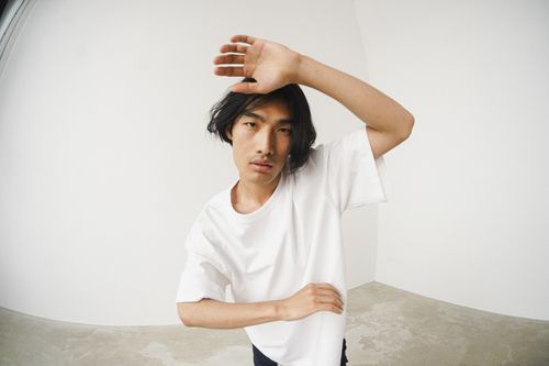 Free Artistic portrait of a man in a white shirt with a minimalist background. Stock Photo