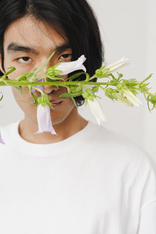 Free Portrait of a man in a white shirt with flowers against a white background. Stock Photo