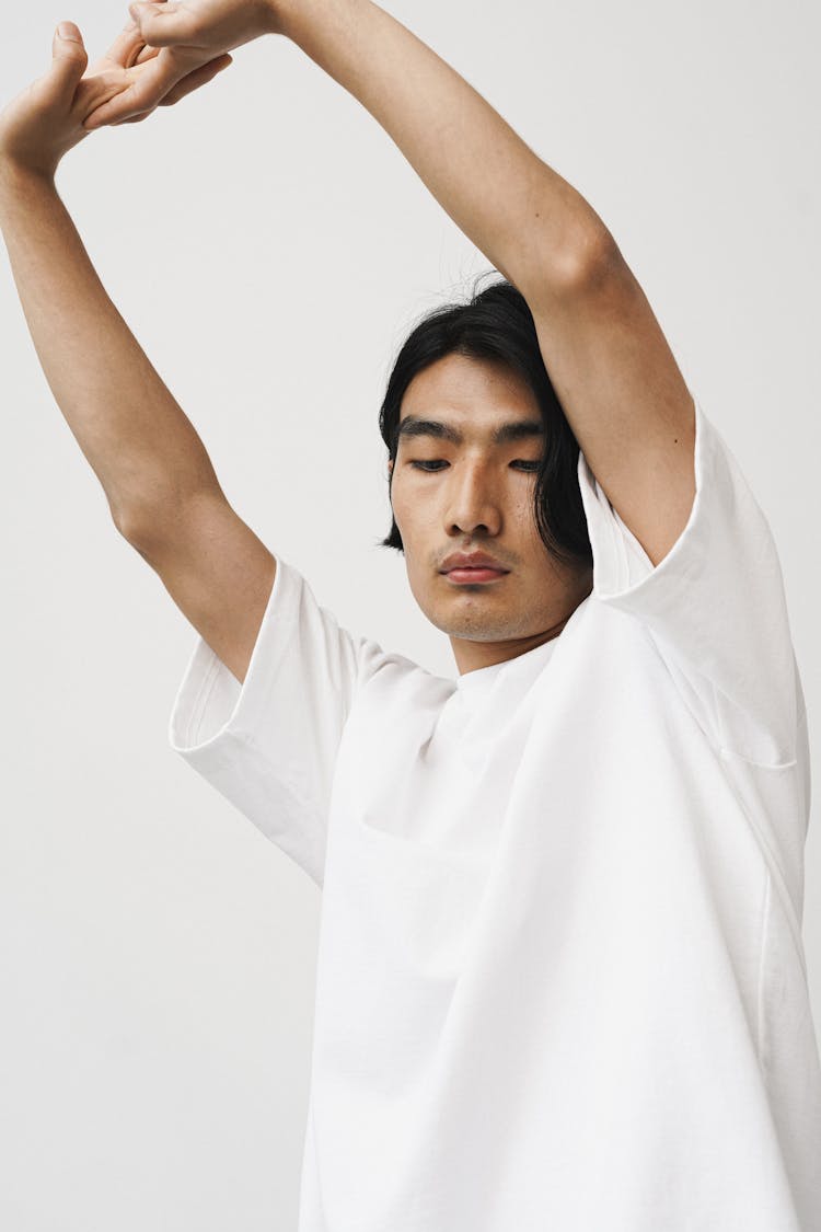 A Man In A White T Shirt Stretching His Arms