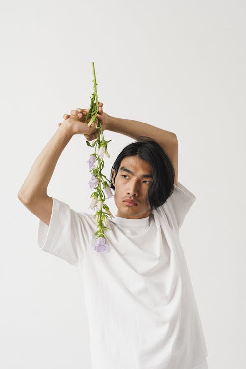 A Man in White Shirt Holding a Flower