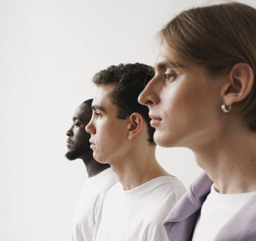 Profile of three diverse men in a white studio background, promoting unity.