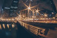 城市的夜间景色壮丽，以明亮的摩天大楼和倒映着灯光的河流为特色