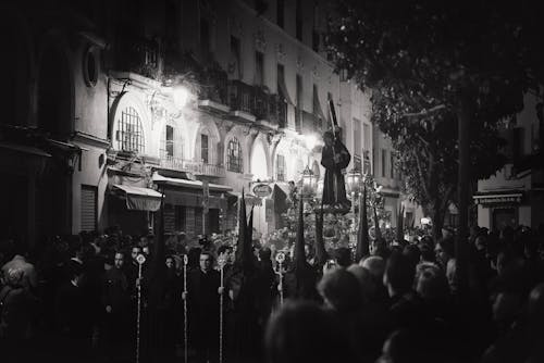 Photo En Niveaux De Gris De Personnes Debout Devant Un Bâtiment En Béton