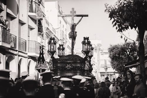 Photo En Niveaux De Gris D'un Groupe De Personnes Transportant Un Crucifix