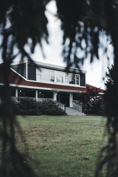 A picturesque view of a charming house with a lush green lawn and distinct red roof.