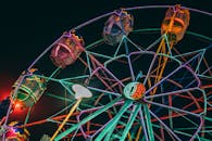 漆黑的夜空中，游乐园里色彩缤纷的摩天轮亮起