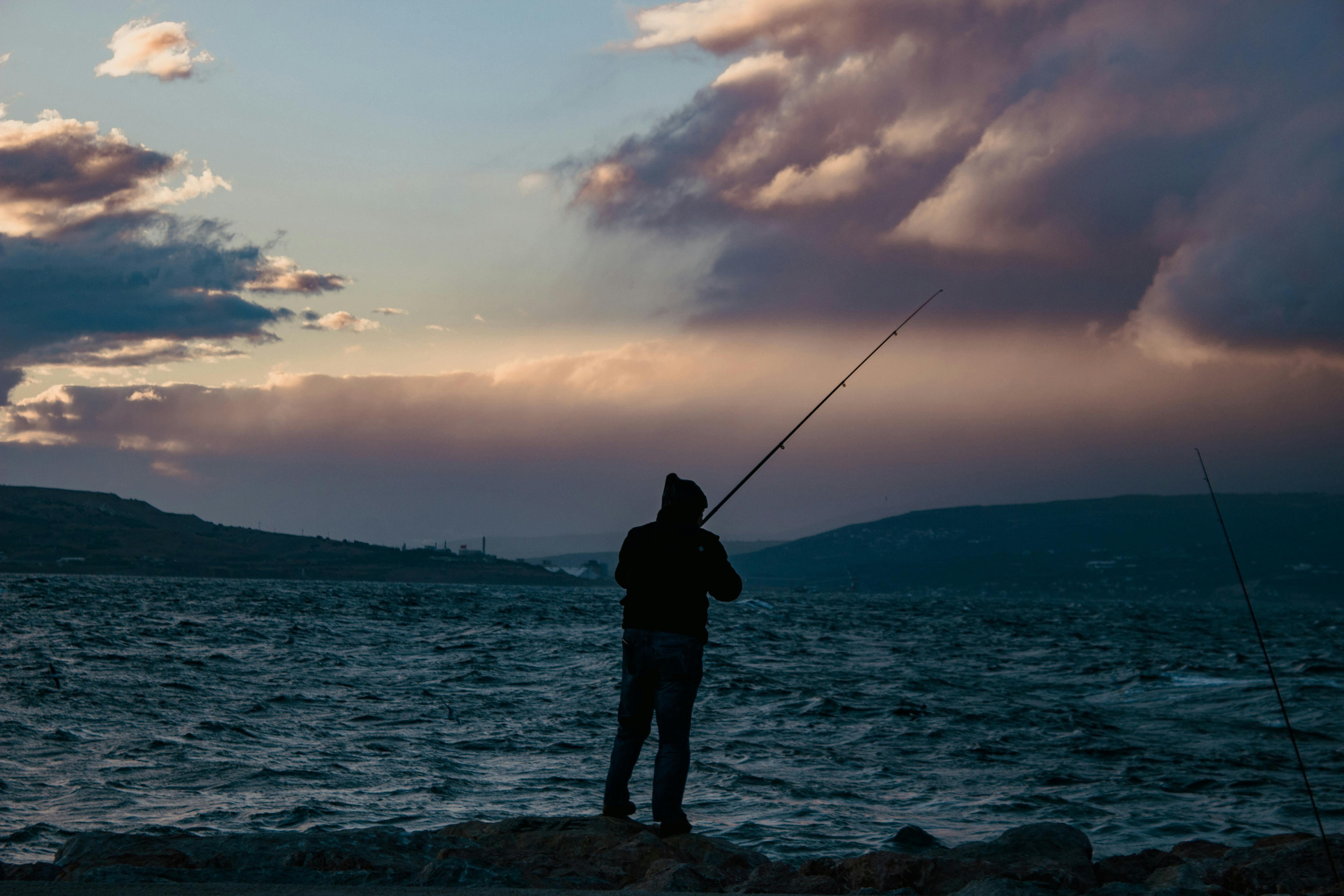 Man in Purple Crew Neck T-shirt Holding Black Fishing Rod · Free