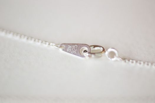 Detailed view of a sterling silver clasp on a necklace chain.