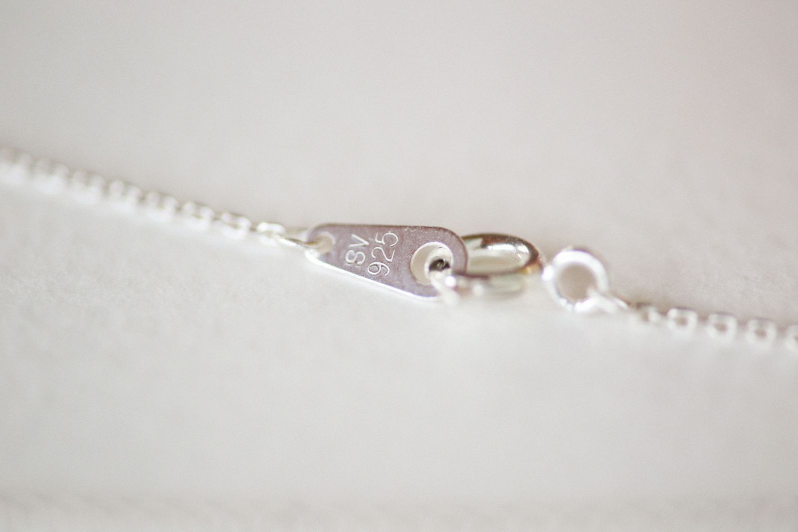 Close-up of the clasp and hallmark on a silver chain