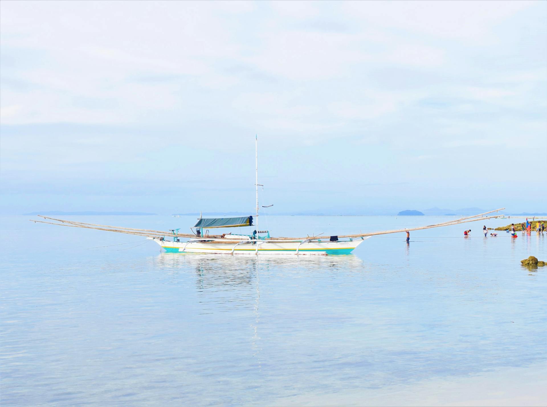 A serene view of a traditional boat floating in calm Philippine waters, perfect for travel and nature themes.