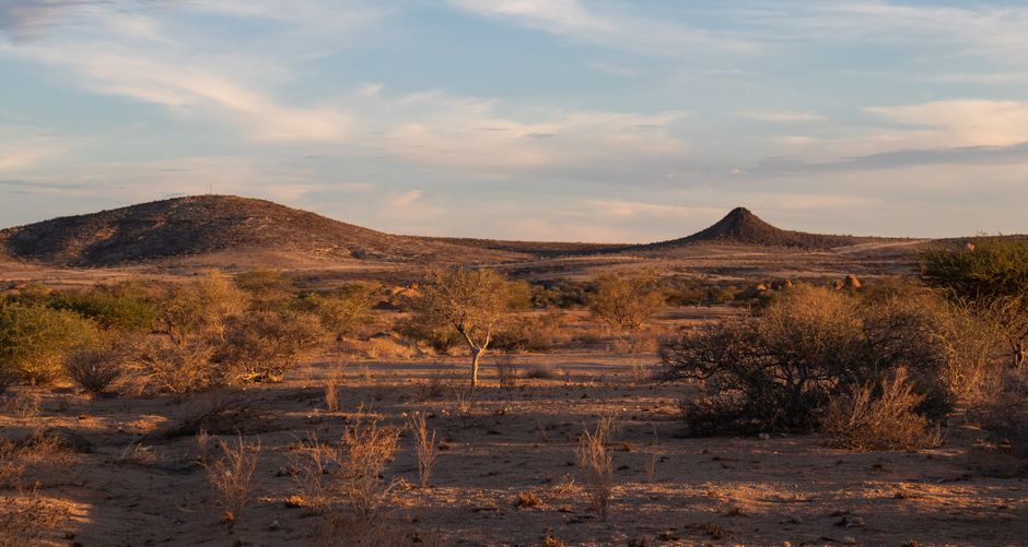 Breathtaking view of the arid Erongo landscape in Namibia featuring distinct hills under a soft, warm sky.