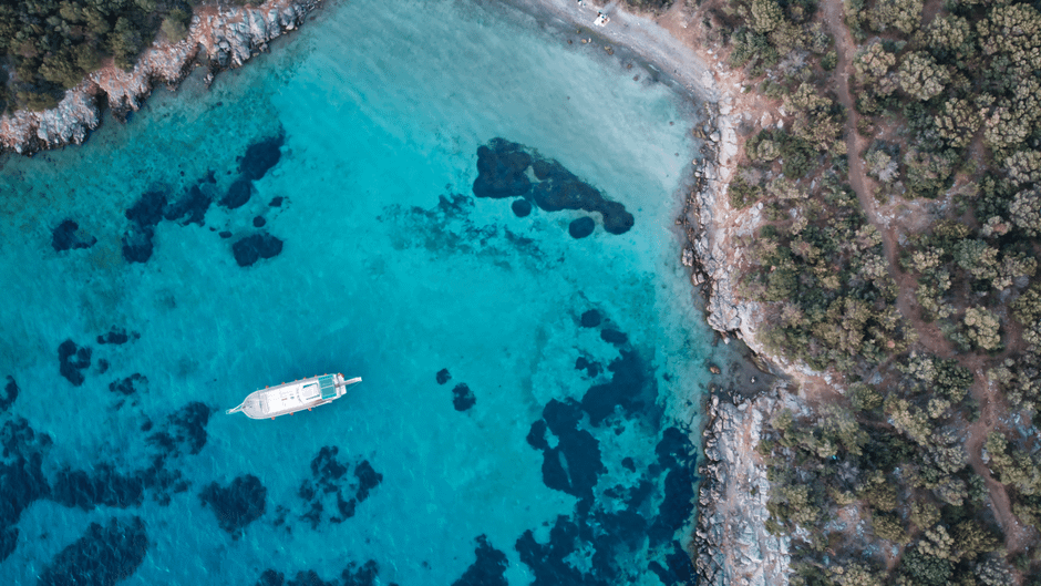 Stunning Bodrum Private Motor-Yacht Sunset Tour With Dinner For 3 Hour Review 2026 - Aerial shot capturing a boat in the clear turquoise waters near Bodrum, Türkiye.