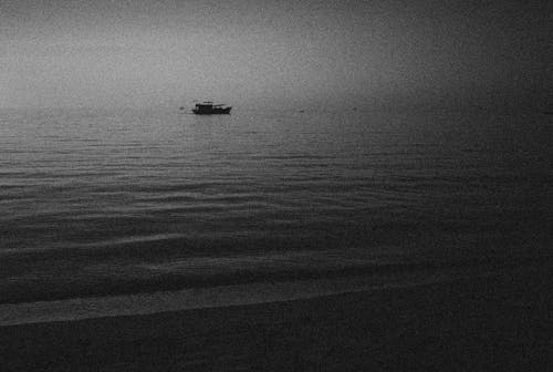 Free Grayscale Photography of Boat on Sea Stock Photo