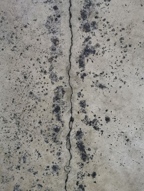 Photo by Karen Laårk Boshoff on Pexels Detailed view of a cracked concrete surface with unique textures and patterns.