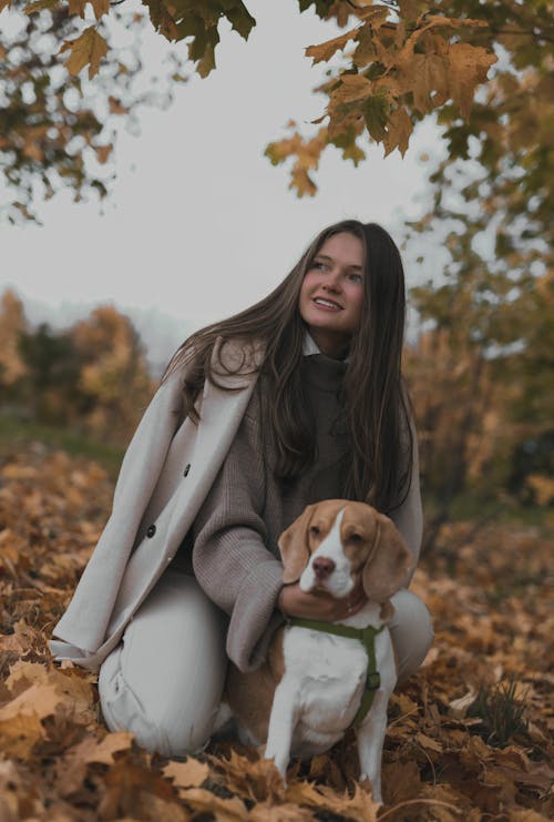 Free A Woman in Trench Coat Petting Her Dog Stock Photo