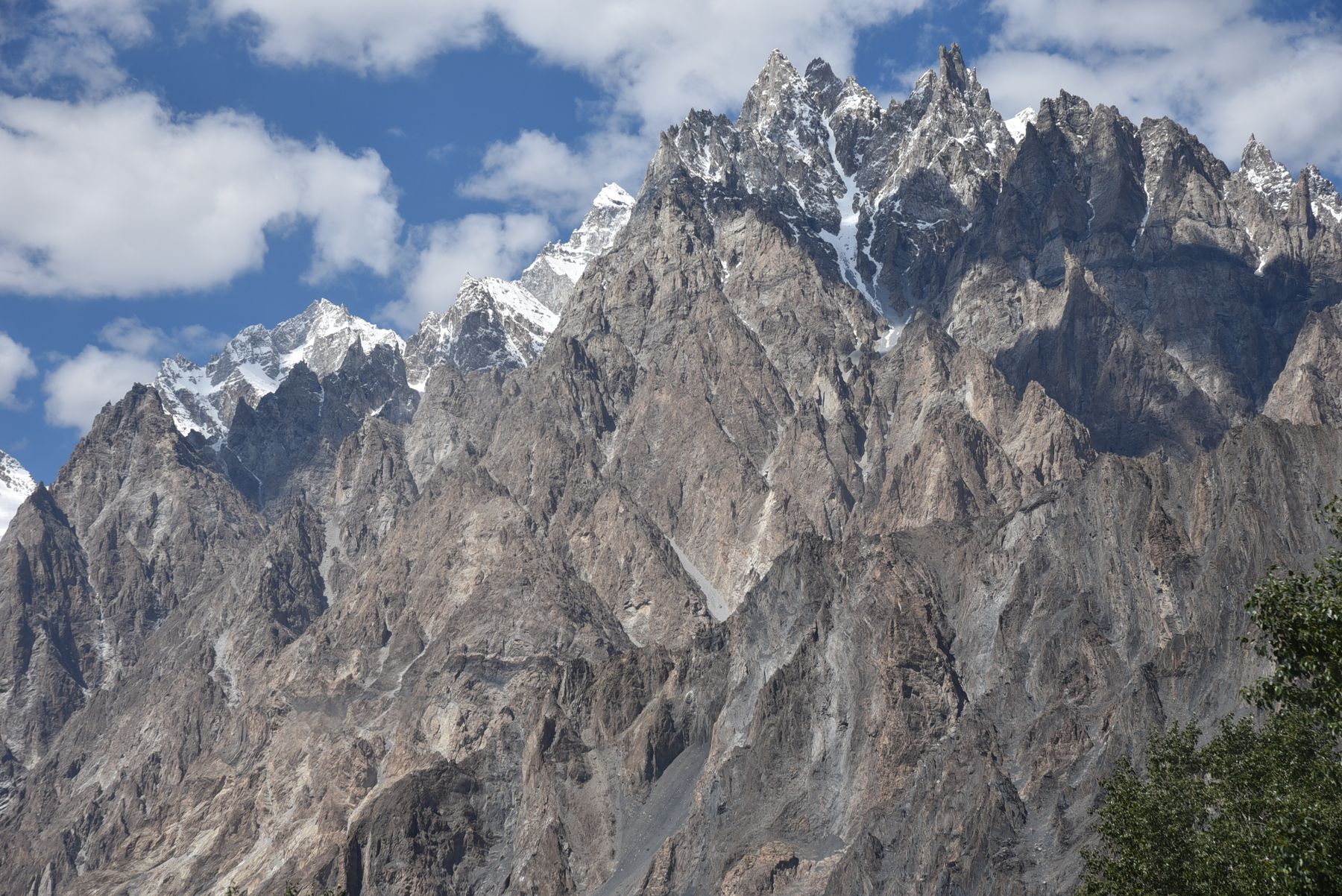 Majestic view of the snow-capped Passu Cones in Pakistan's Karakoram Mountain Range under a clear blue sky.