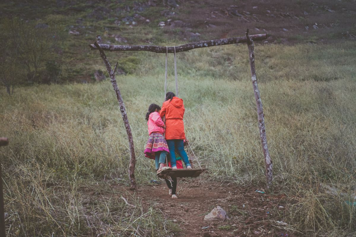 Kids playing on a swing during outdoor games for kids