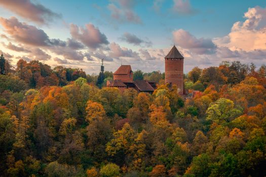 Breathtaking aerial view of Turaida Castle surrounded by vibrant autumn foliage in Sigulda, Latvia.