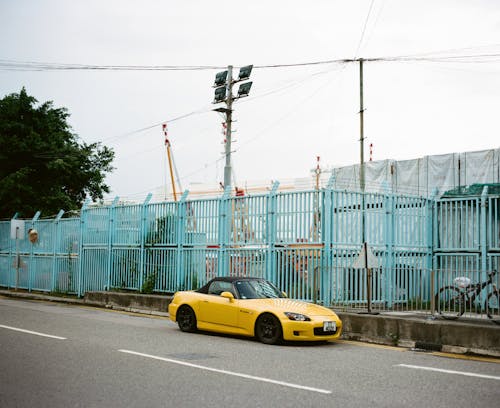 Free A Yellow Honda S2000 Parked by the Roadside in an Urban Area Stock Photo