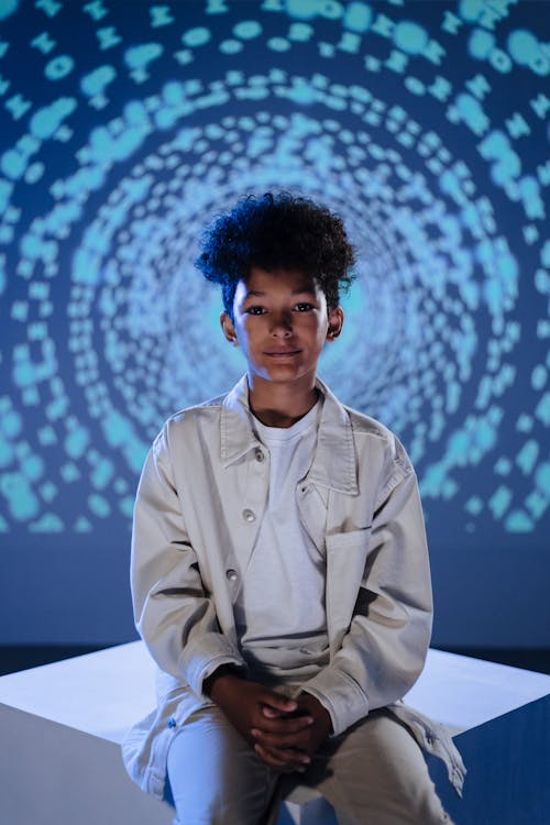 Young Boy Sitting on the Background of a Projection of Numbers 