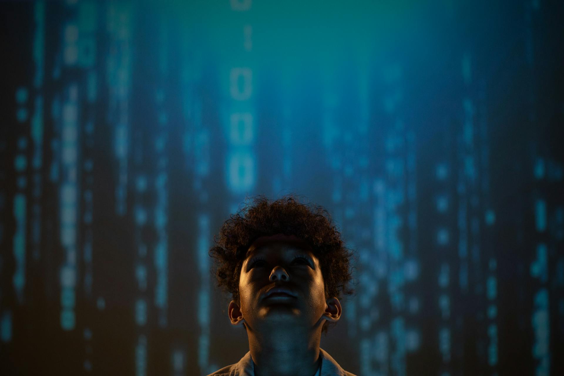 A young boy gazes upward in a digital matrix background, creating a futuristic and conceptual atmosphere.