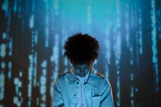 Teenage boy in a futuristic setting with digital blue background, creating a conceptual mood.