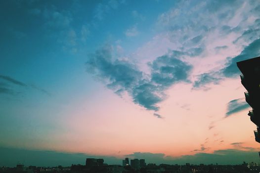 城市天际线上，日落色彩鲜艳，云层形态令人惊叹