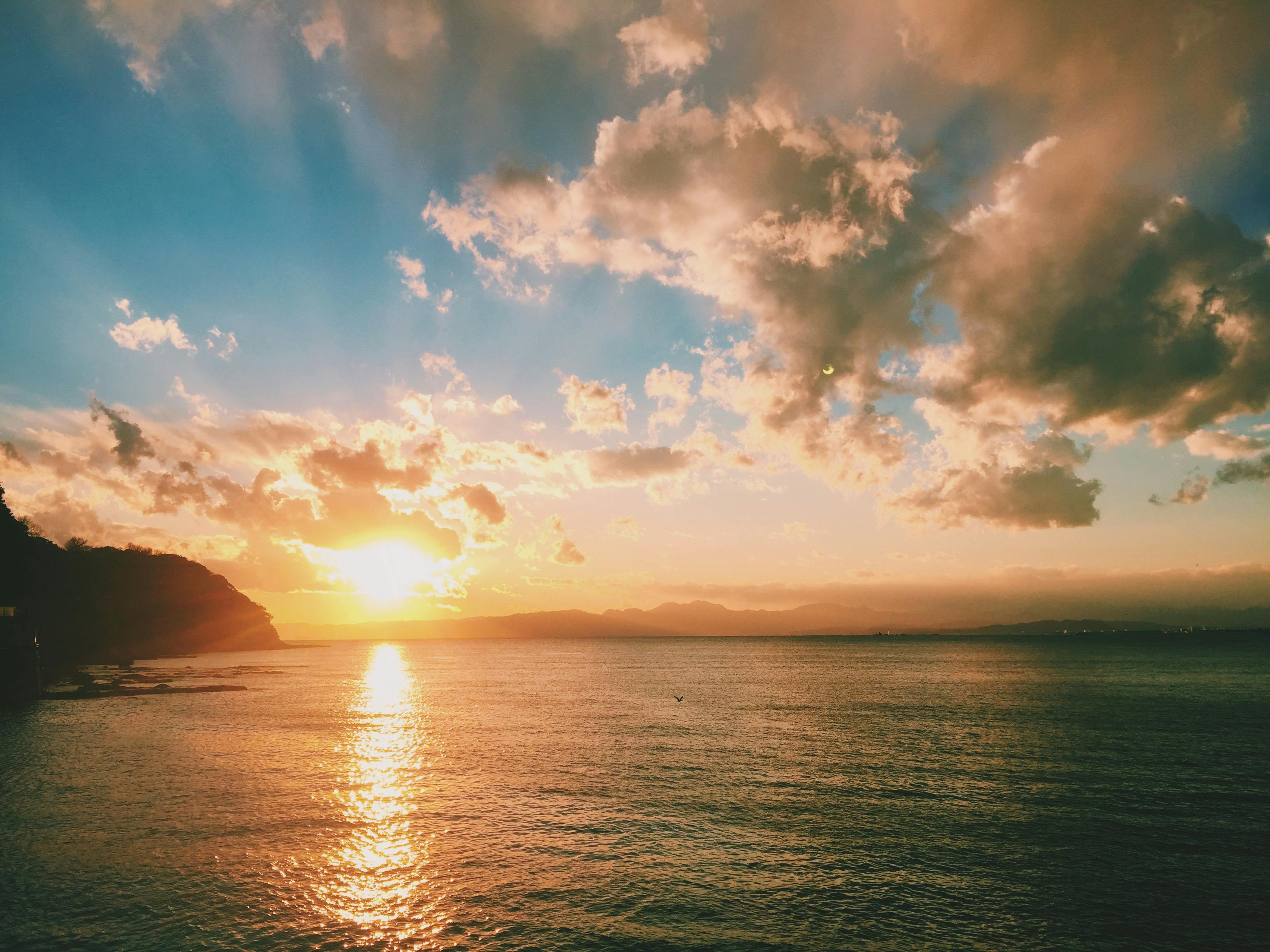 在日本神奈川县藤泽市的海面上，宁静的海景捕捉到了令人惊叹的日落和充满活力的天空