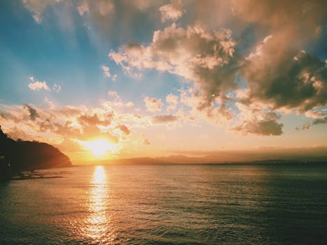 在日本神奈川县藤泽市的海面上，宁静的海景捕捉到了令人惊叹的日落和充满活力的天空