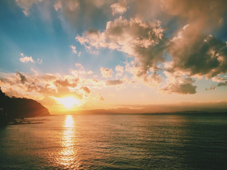 神奈川県藤沢市の海に沈む美しい夕日が、鮮やかな空とともに穏やかな海の風景を捉えています。