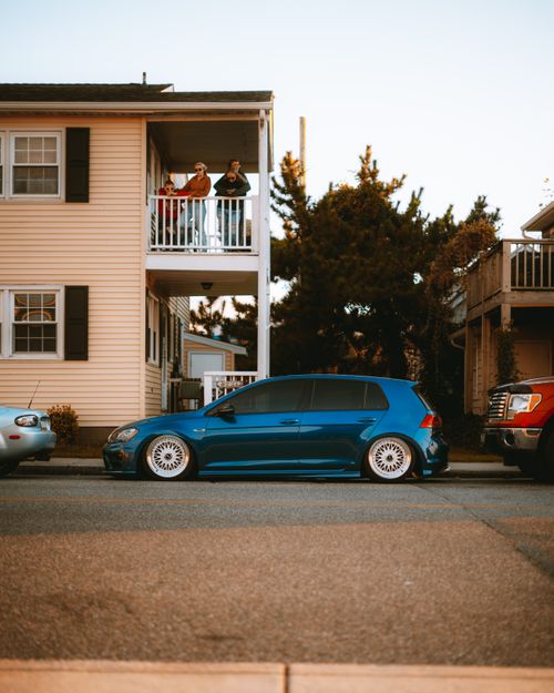 Free A suburban house with parked cars on a quiet street during daytime. Stock Photo
