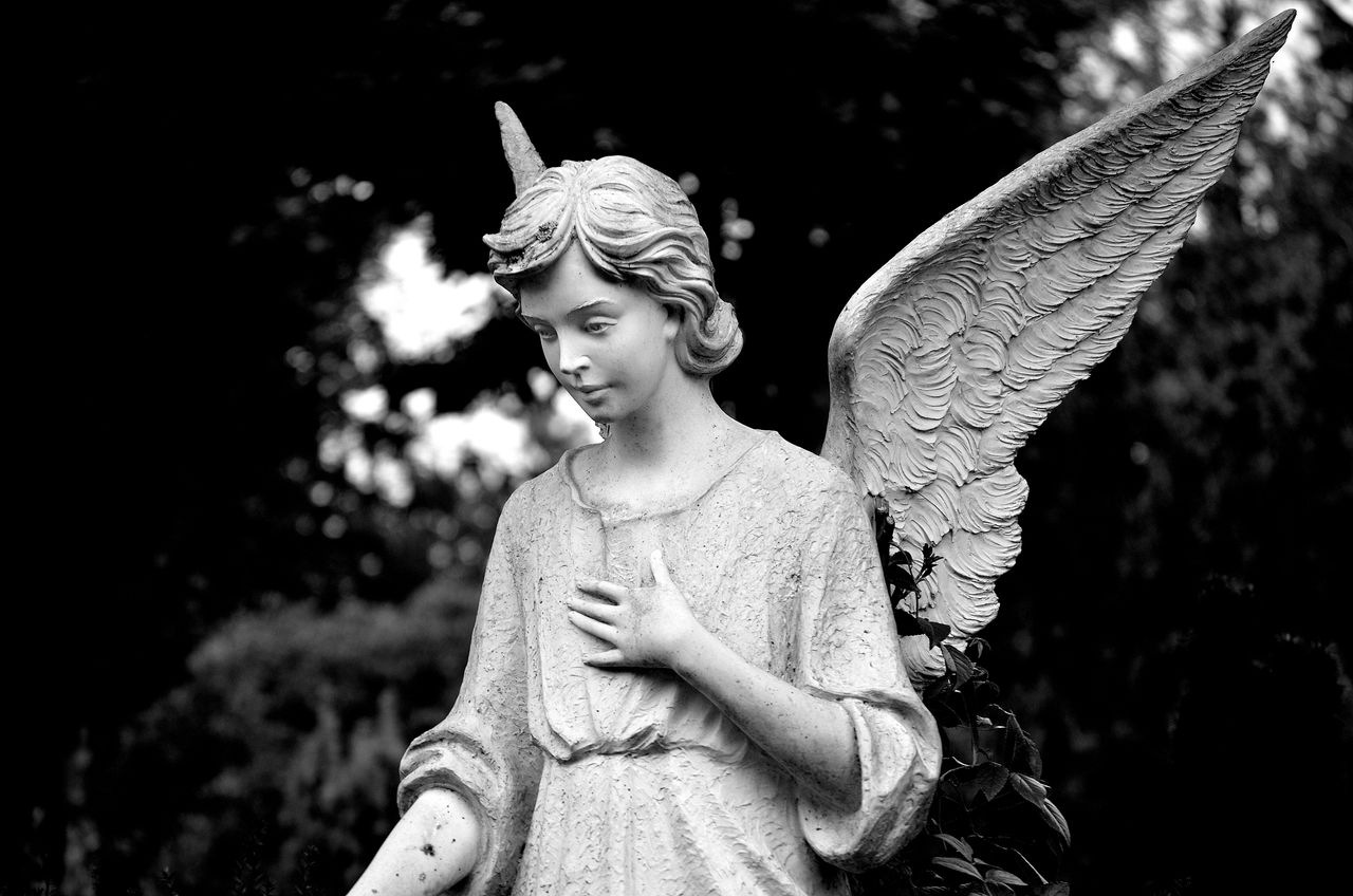 black and white image of a serene angel statue with wings in bocholt c