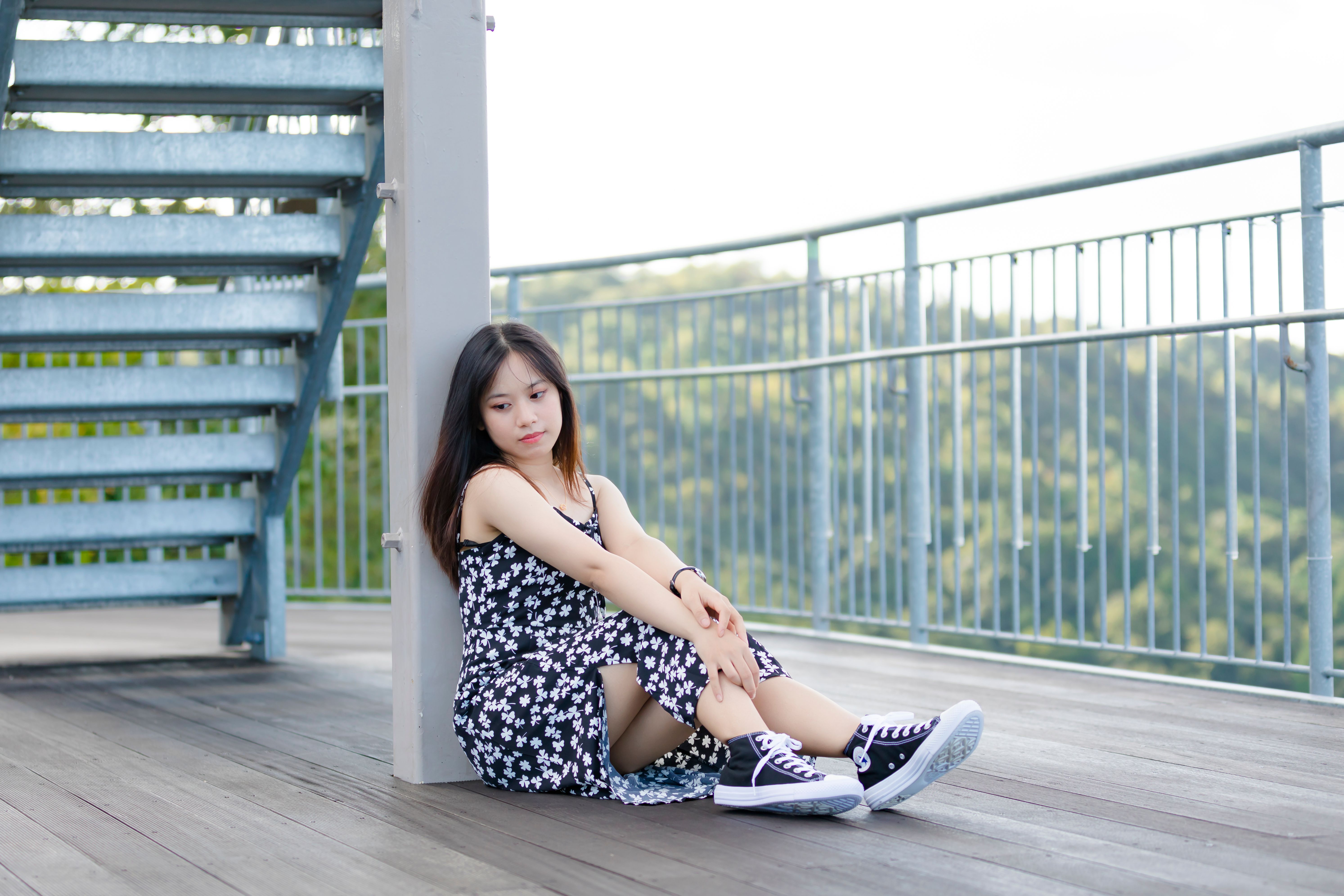 A Woman in a Dress and Chucks Sitting on the Floor · Free Stock Photo
