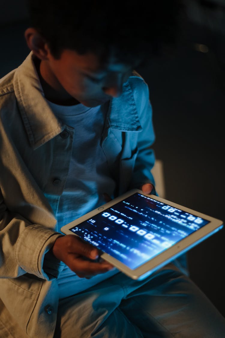 Boy Holding IPad In The Darkness