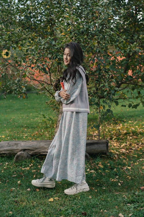 Woman in Gray sweater Walking Beside a Tree