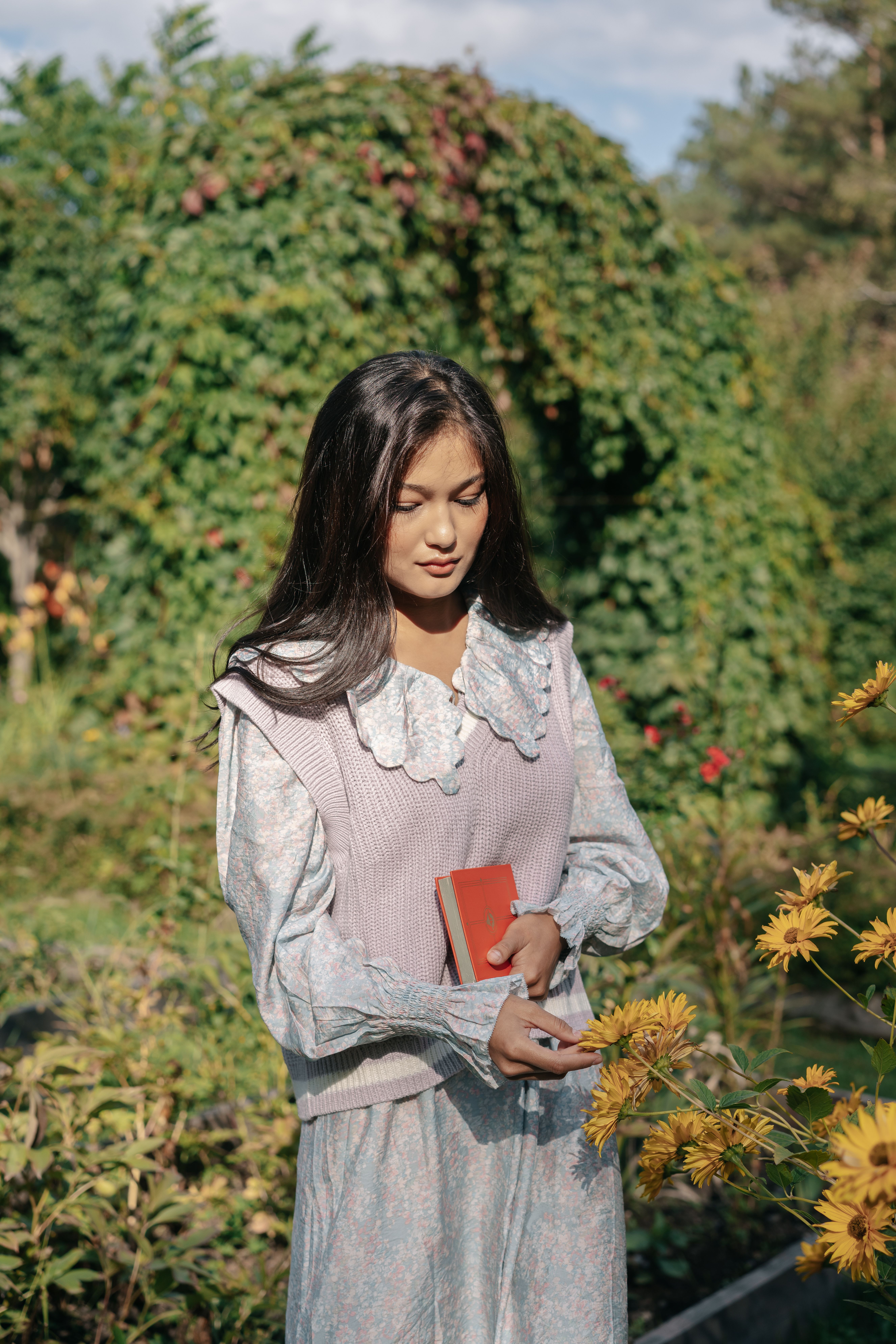 Woman Standing in the Garden Holding Yellow Flowers · Free Stock Photo