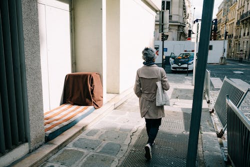 Woman in Brown Coat Walking on Sidewalk