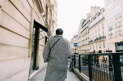 Back View of a Person Walking on a Sidewalk