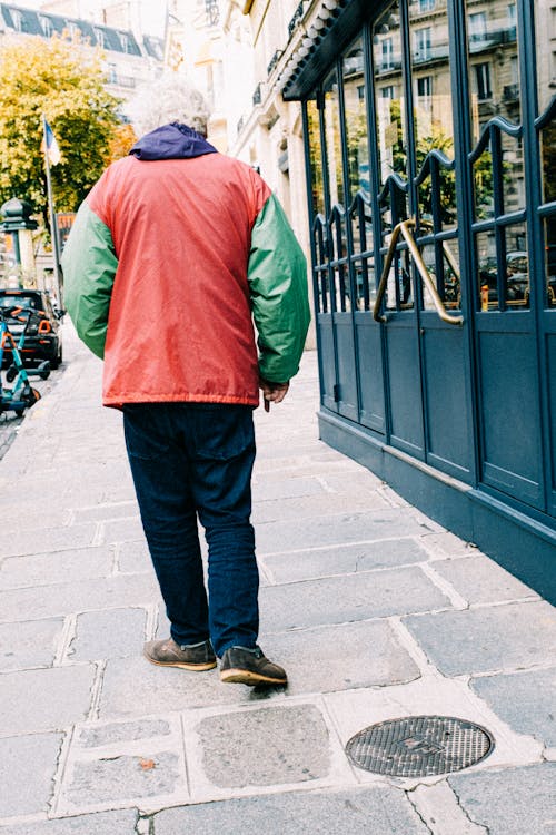 Back View of a Person Walking on the Sidewalk