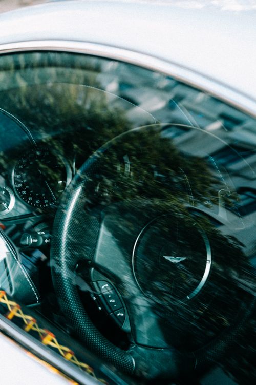 Free Interior view of a luxury car with reflections on the window showing steering wheel and dashboard. Stock Photo