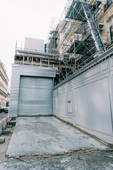 City building under renovation with scaffolding and concrete foundation.