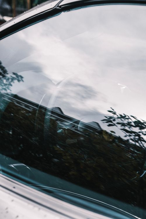 Free Reflection of a cloudy sky in a car window, highlighting vehicle design. Stock Photo