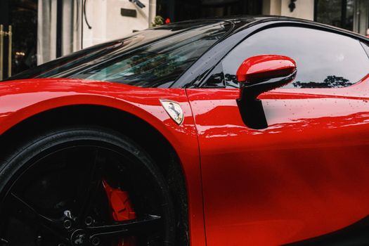 Detailed shot of a luxurious red supercar highlighting sleek design elements and glossy finish.
