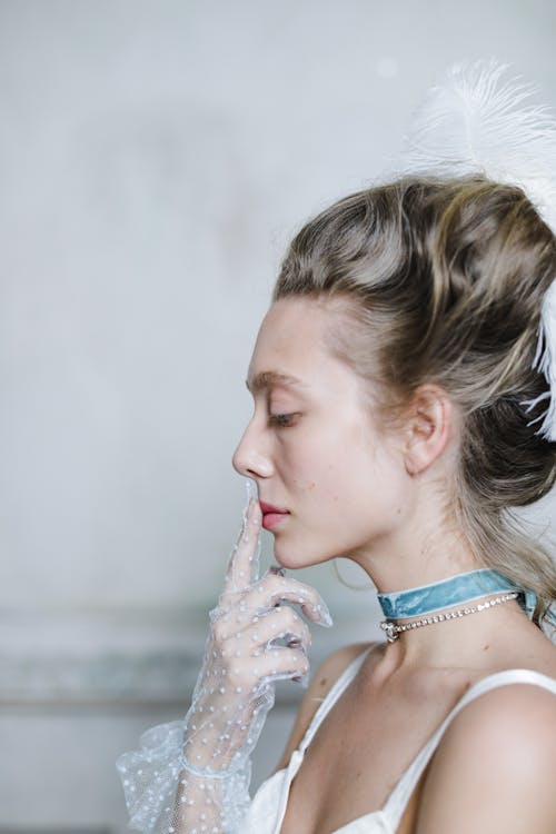 Woman Wearing a Lace Glove with Hand on Lips